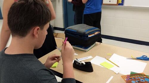 Student working with pen, paper, and tape